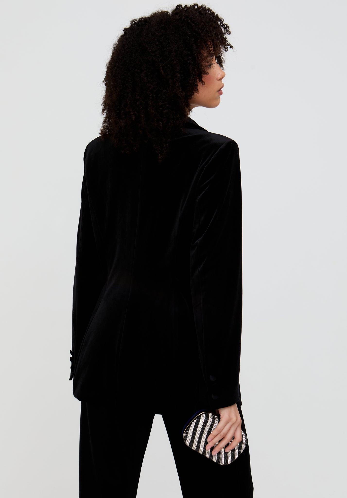 Person wearing a black velvet jacket on a white background