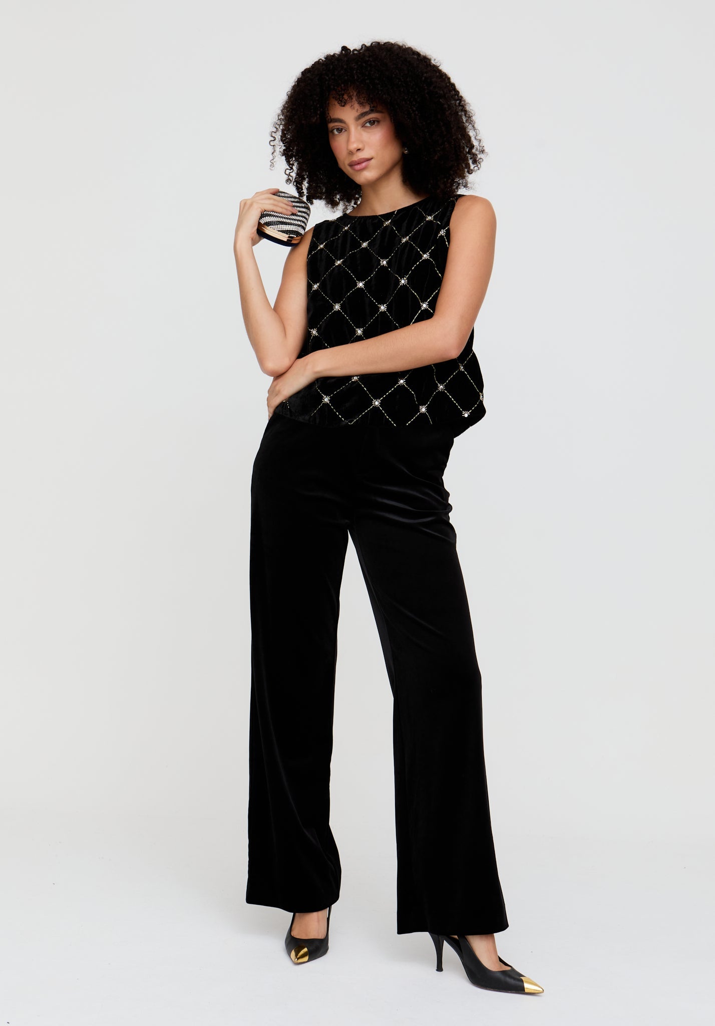 Woman wearing a black quilted top and pants on a white background