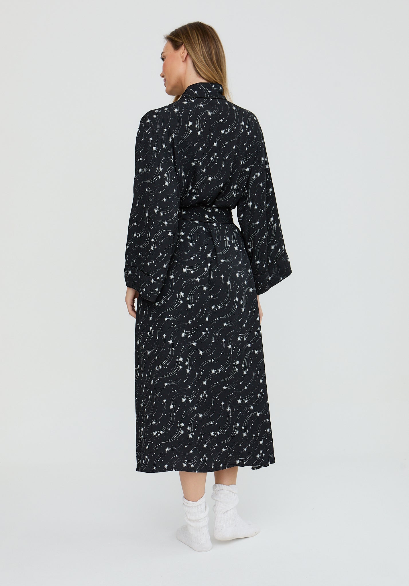 Woman wearing a black patterned dress on a white background