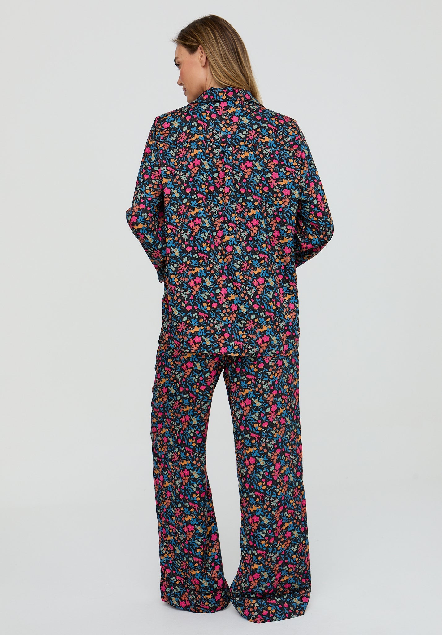 Person wearing a colorful floral pajama set on a white background