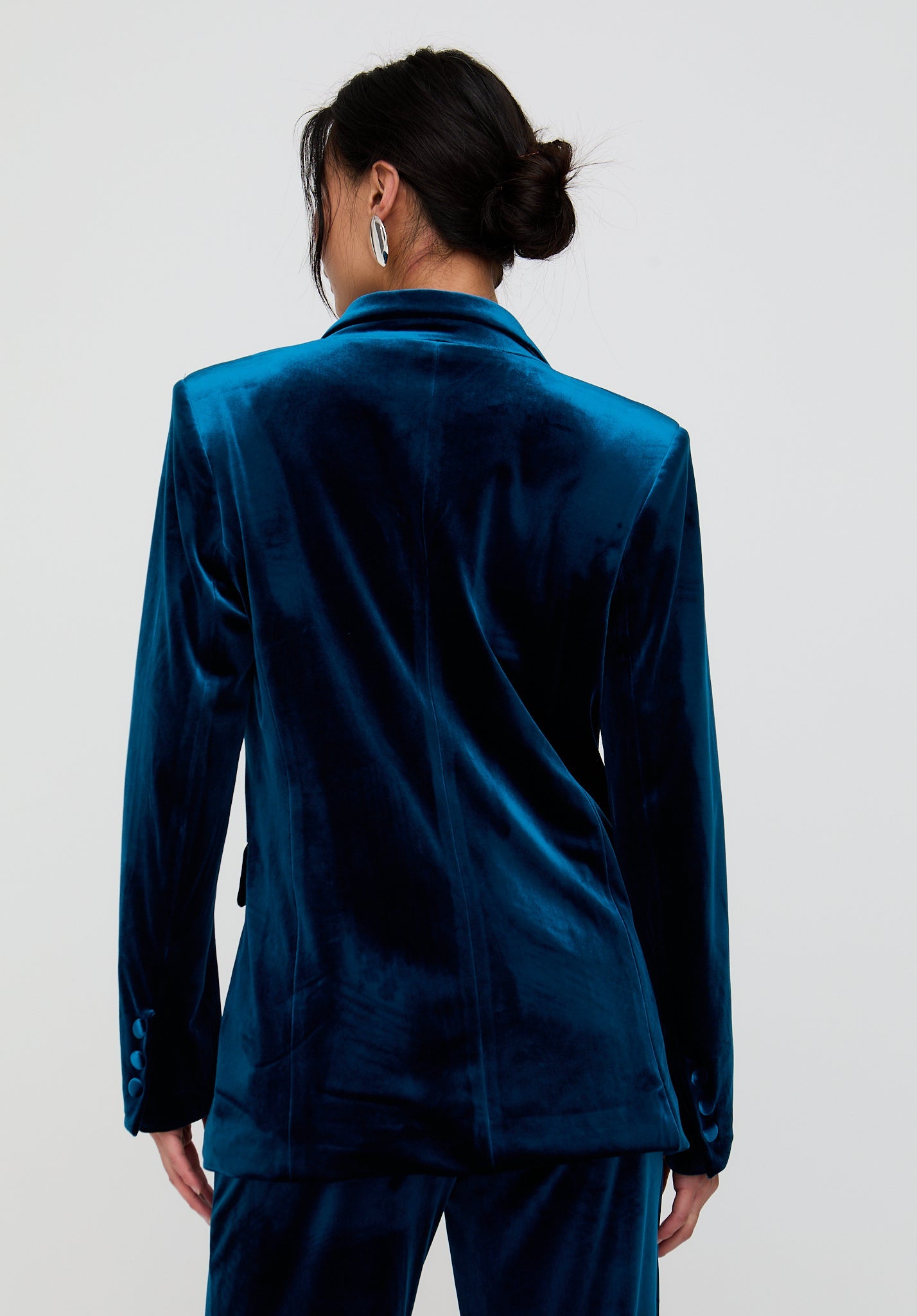 Person wearing a blue velvet suit on a plain background