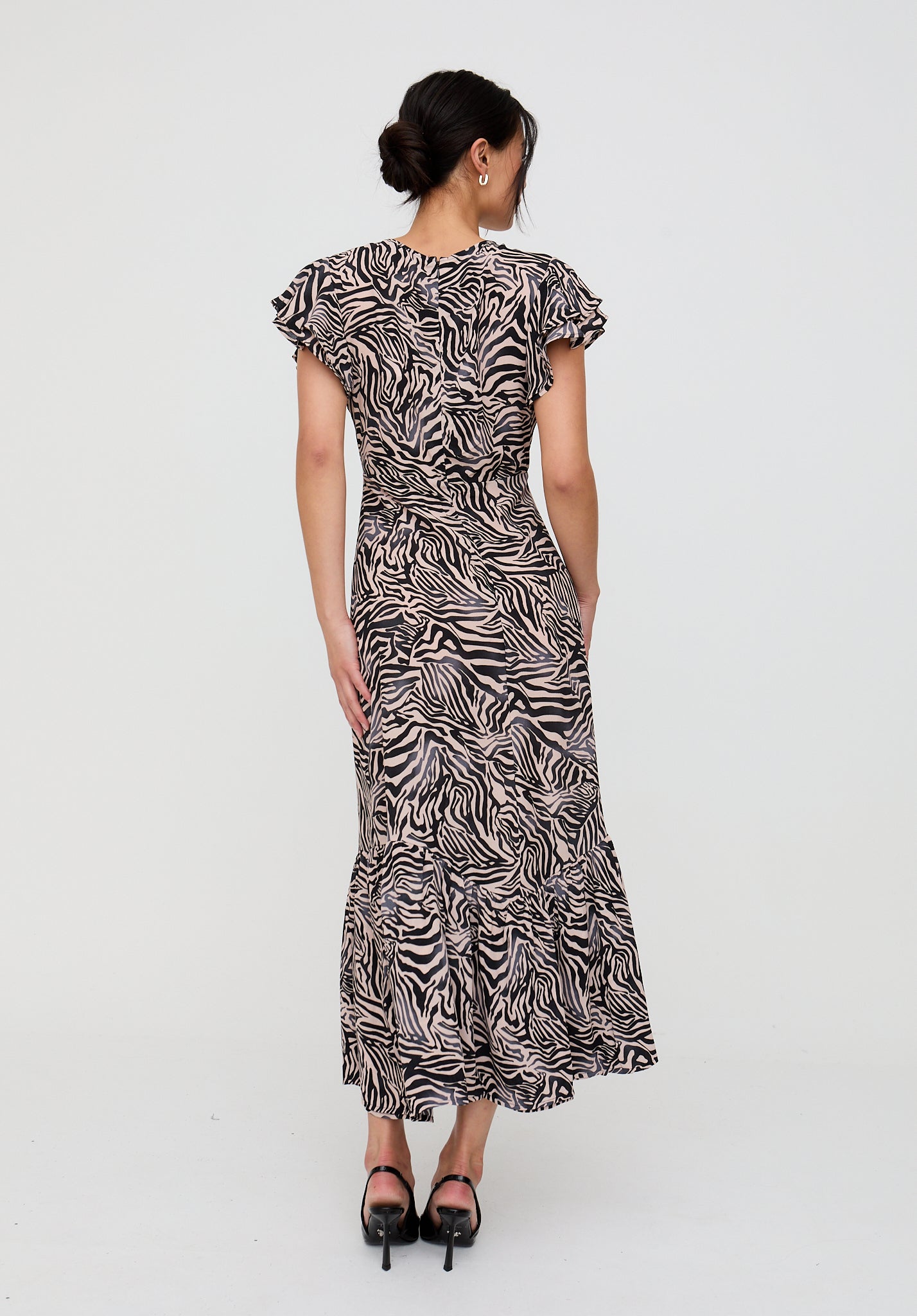 Woman wearing a zebra print dress on a white background