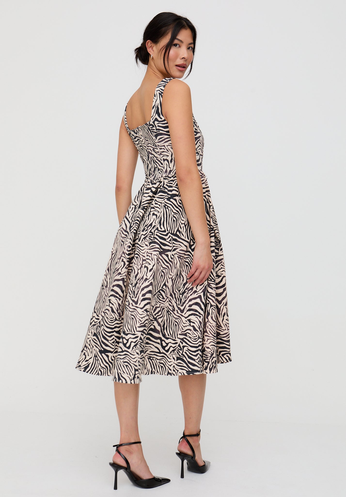 Woman wearing a zebra print dress on a white background