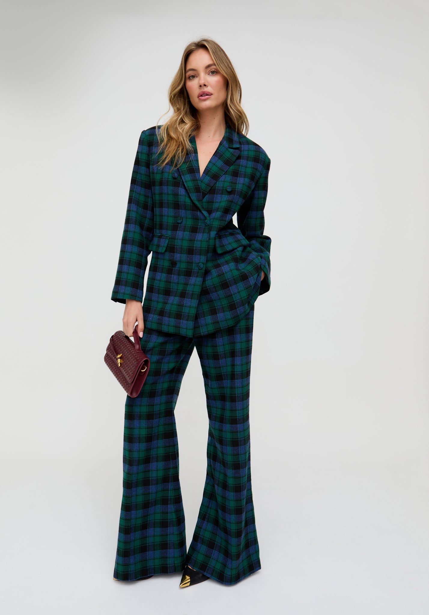 Woman wearing a green plaid suit with a white background