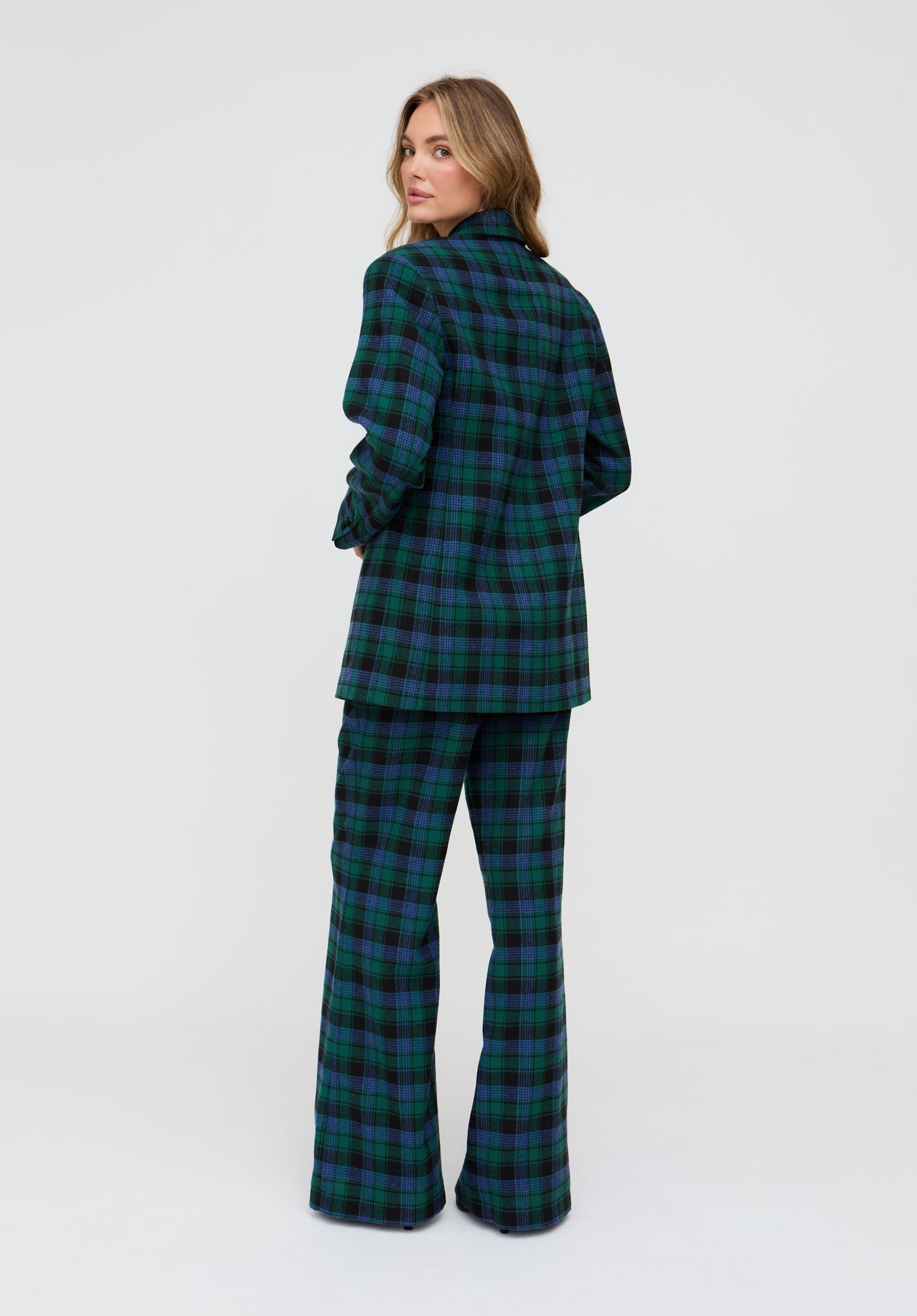 Woman wearing a green and blue plaid outfit on a white background