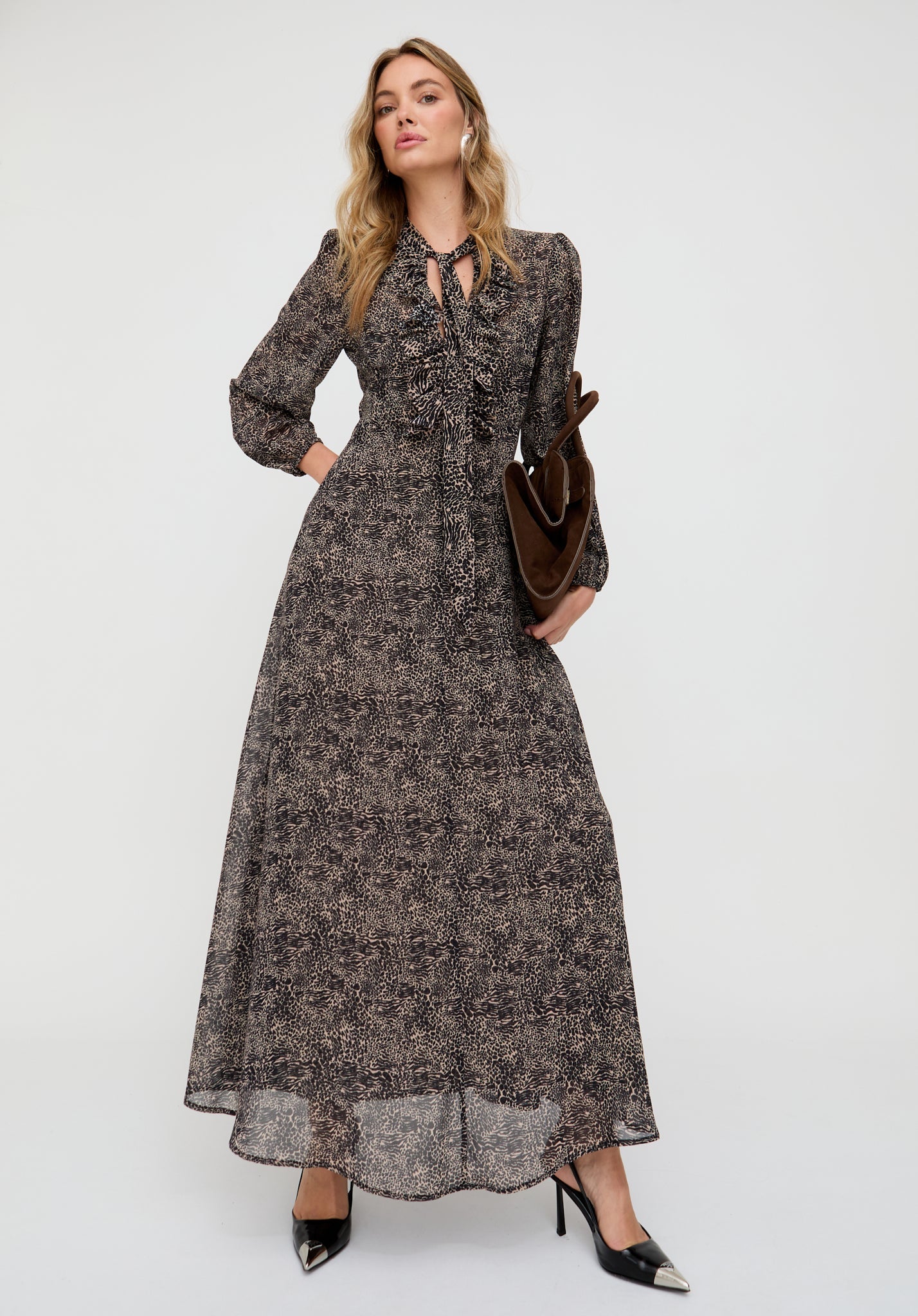 Woman wearing a long floral dress with a plain background