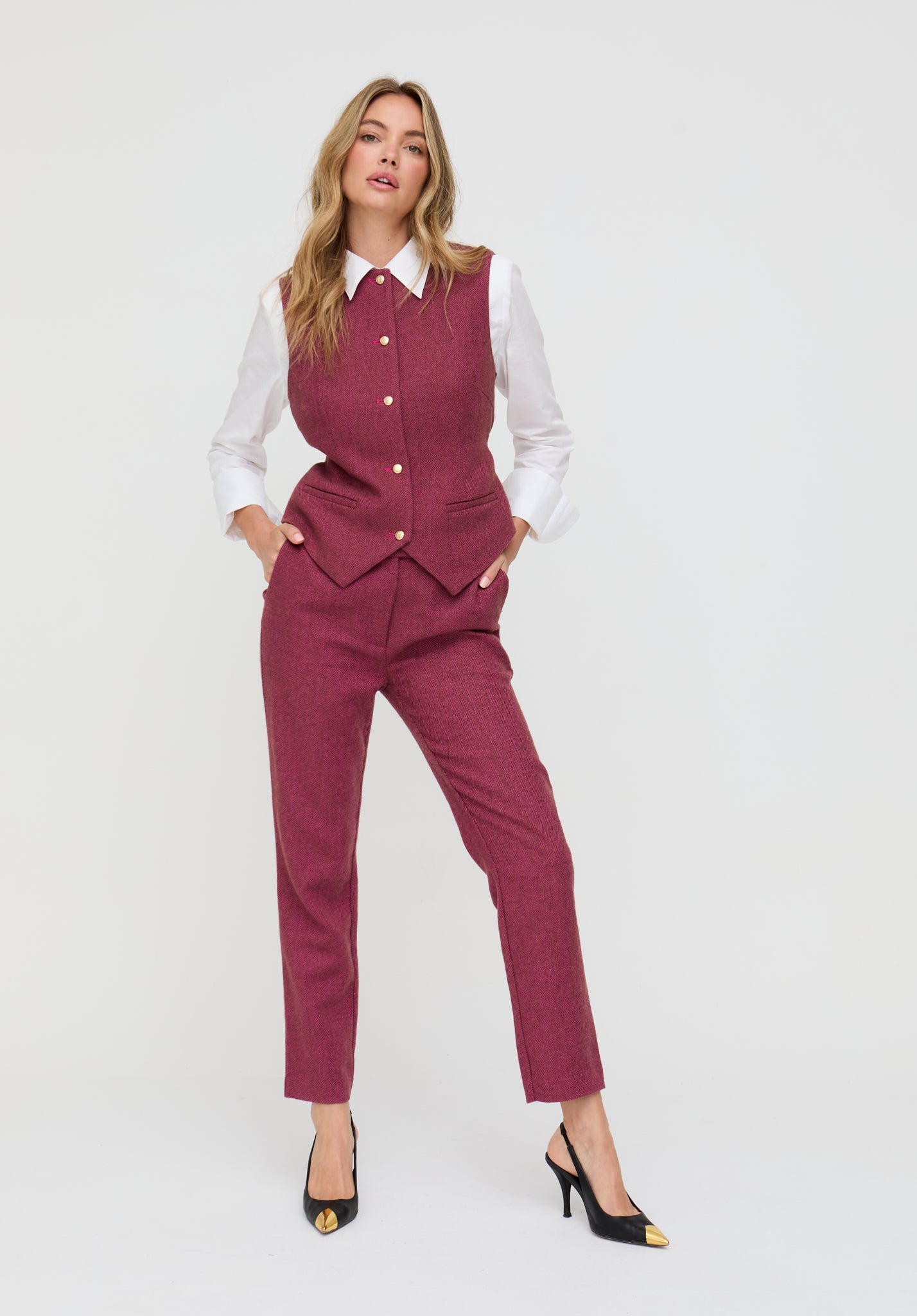 Woman wearing a burgundy suit with a white shirt on a white background