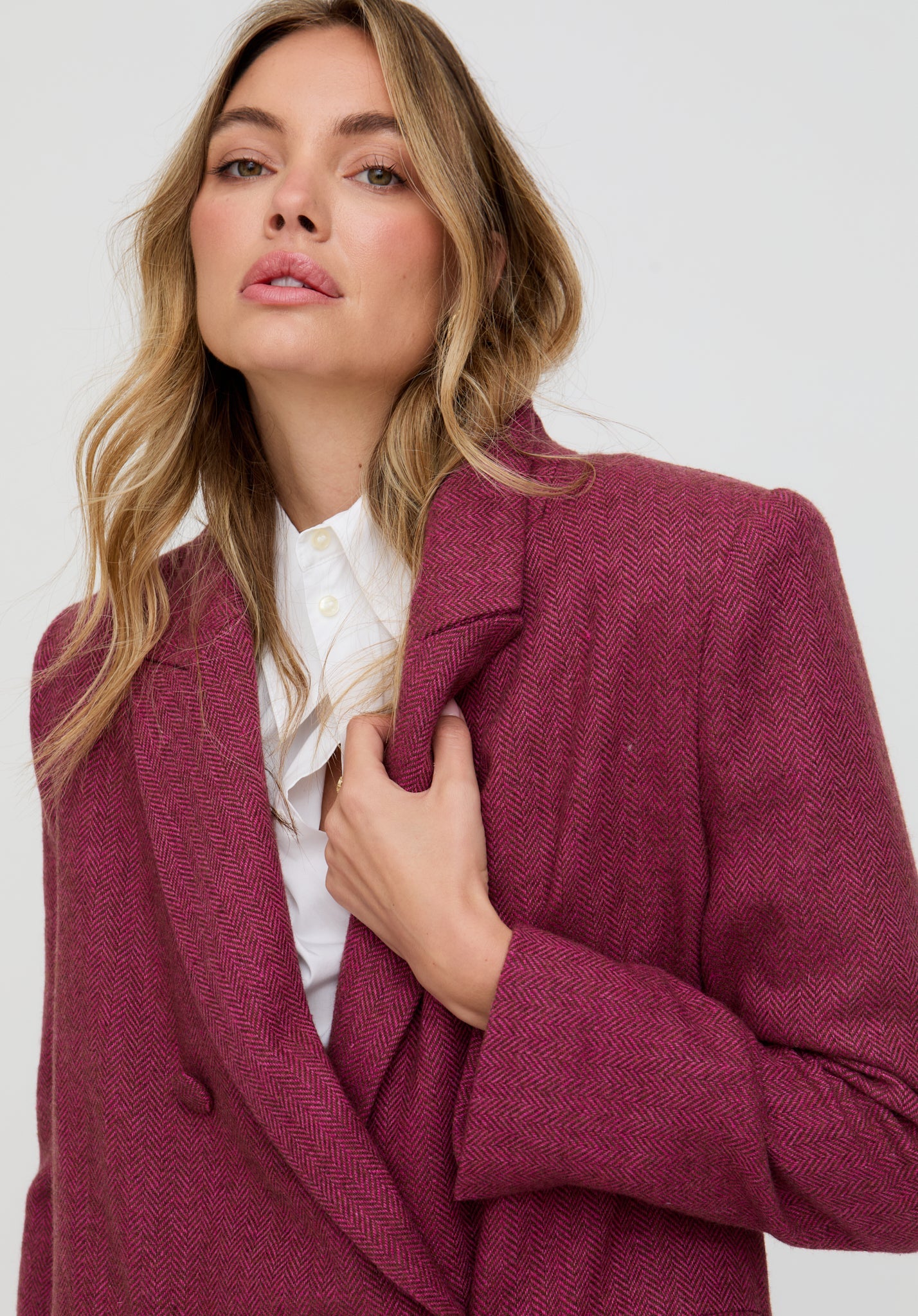 Woman wearing a burgundy coat against a white background