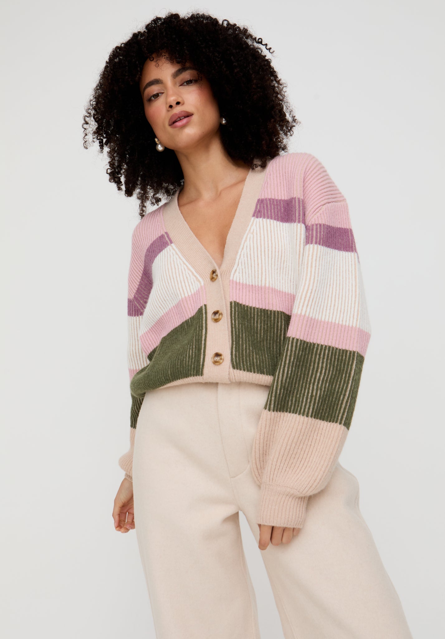Woman wearing a colorful striped cardigan against a white background