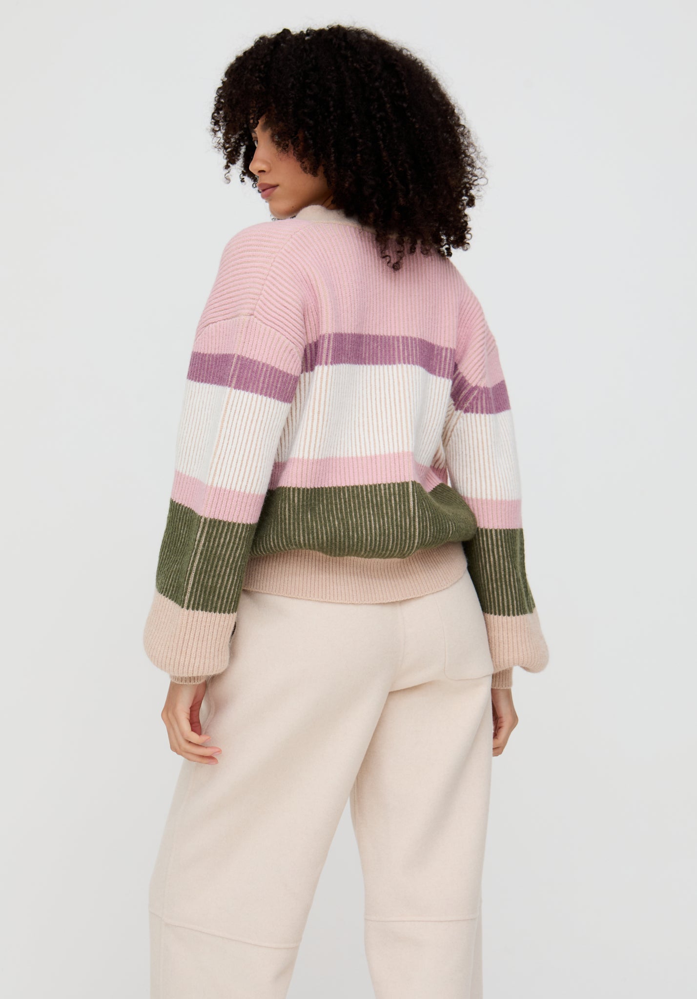 Person wearing a colorful striped sweater on a white background