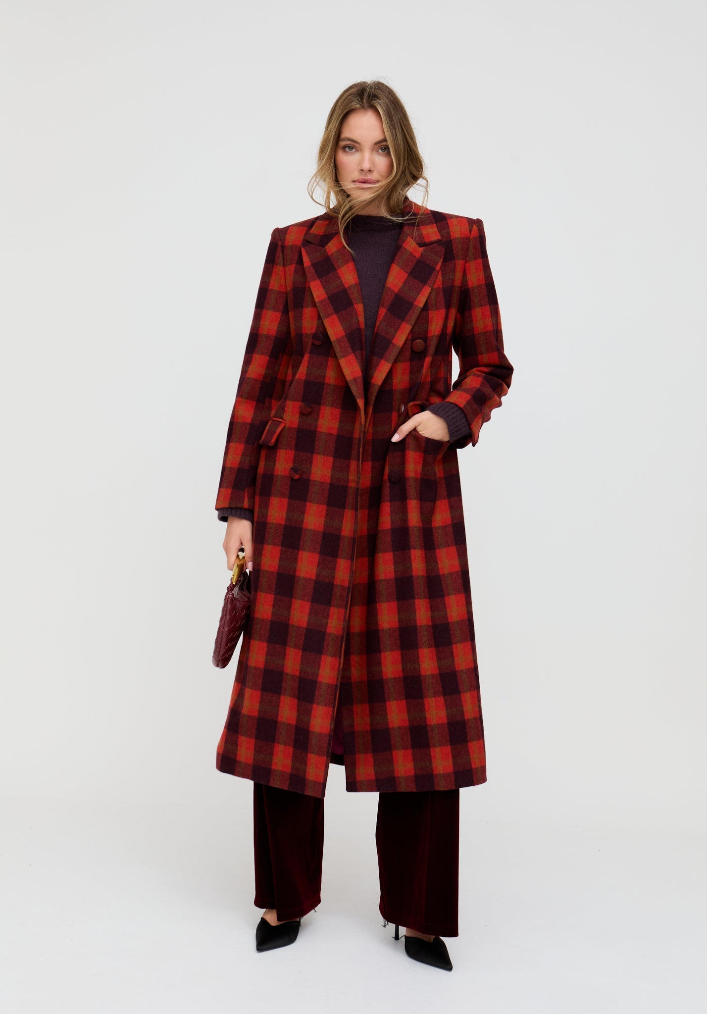 Woman wearing a red and black checkered coat on a white background