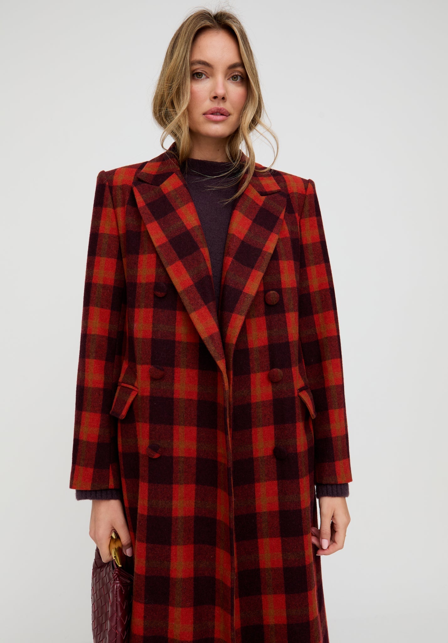 Woman wearing a red and black plaid coat on a white background