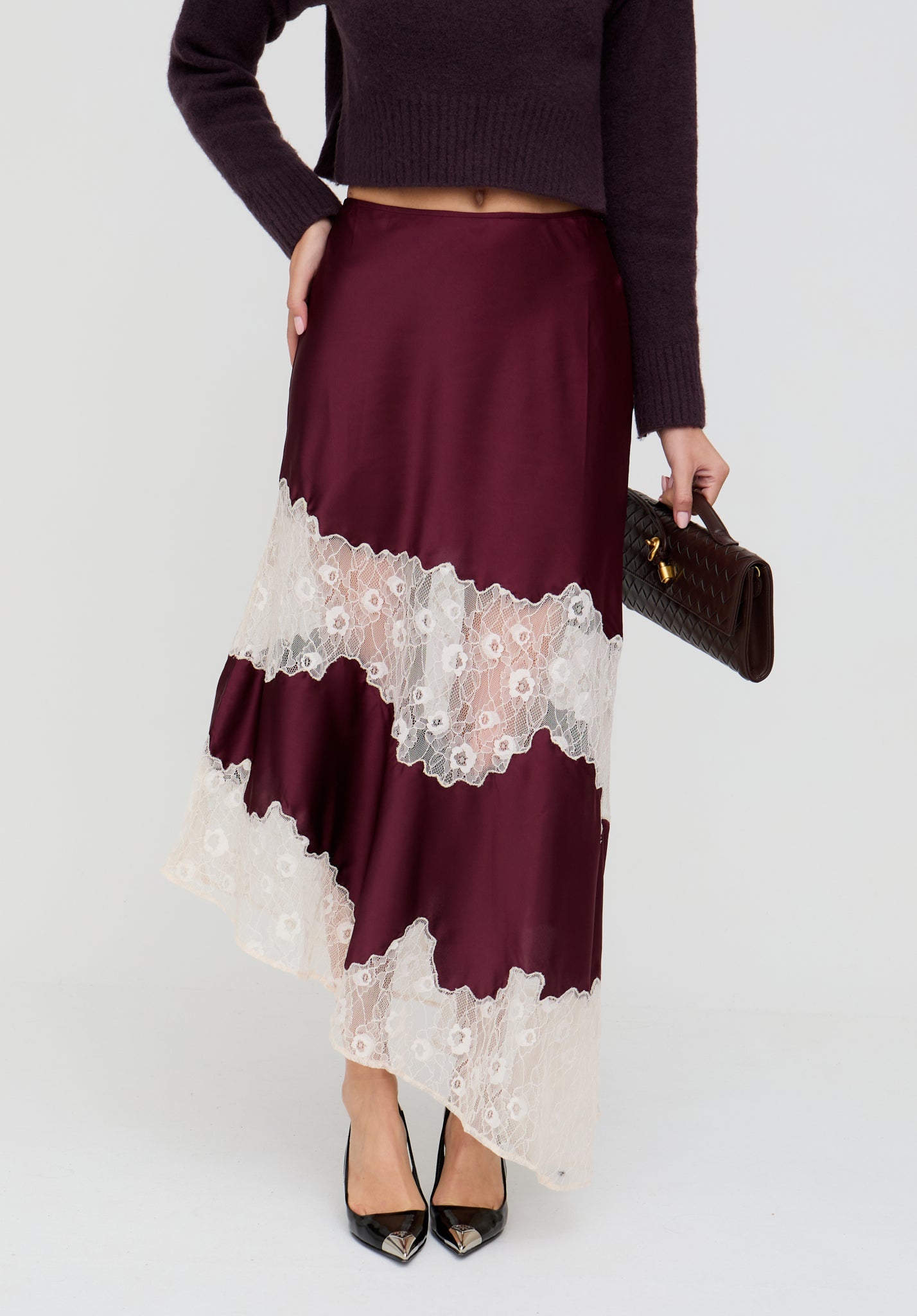 Burgundy skirt with lace details worn by a person on a white background