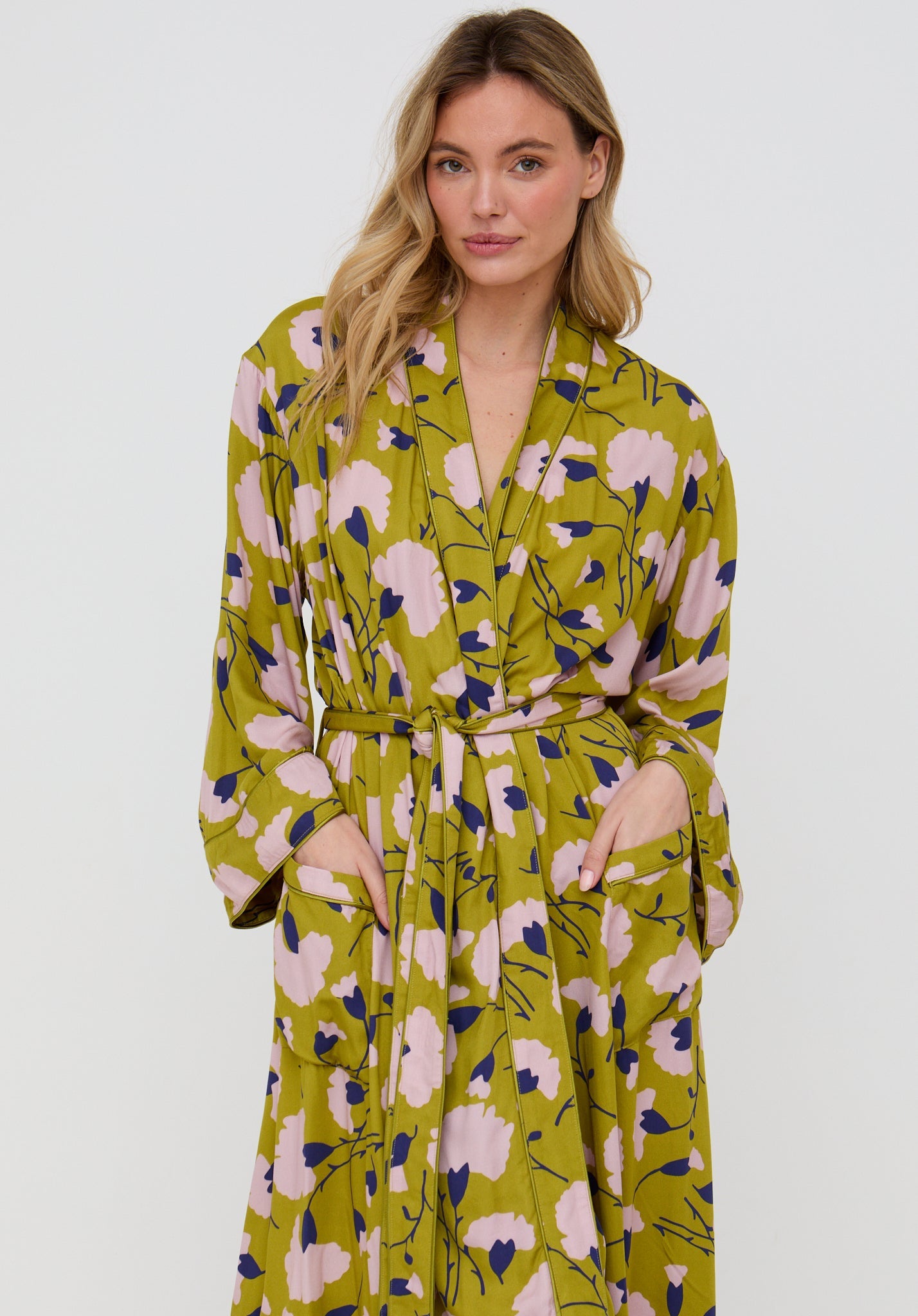 Woman wearing a floral patterned robe on a plain background