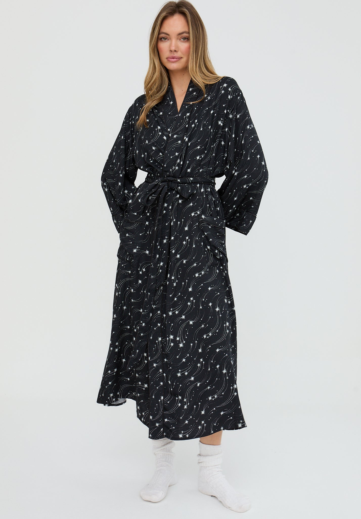 Woman wearing a black patterned dress on a white background