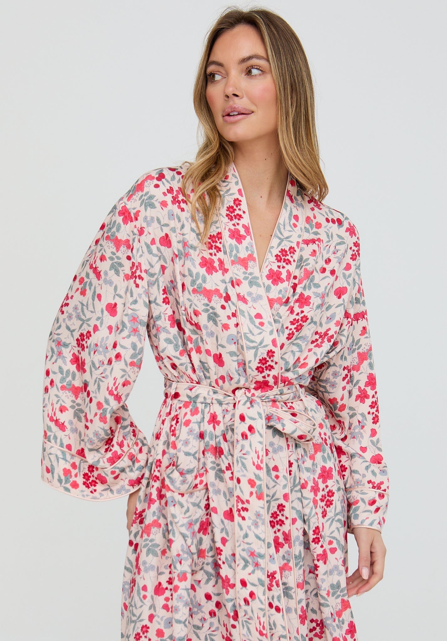Woman wearing a floral robe on a plain background