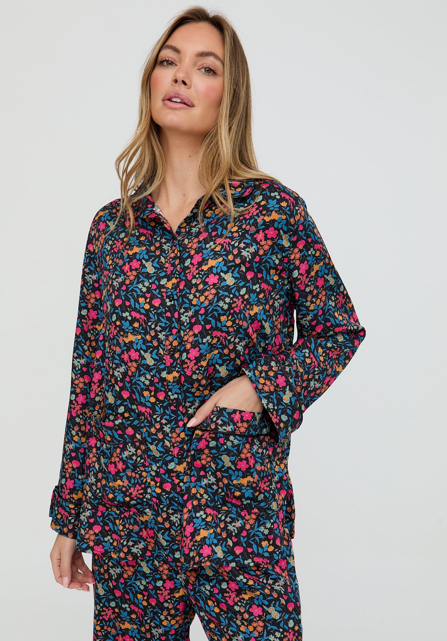 Woman wearing a floral pajama set against a white background