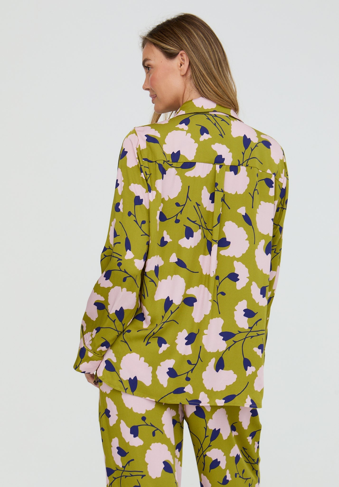 Woman wearing a green floral patterned outfit on a white background