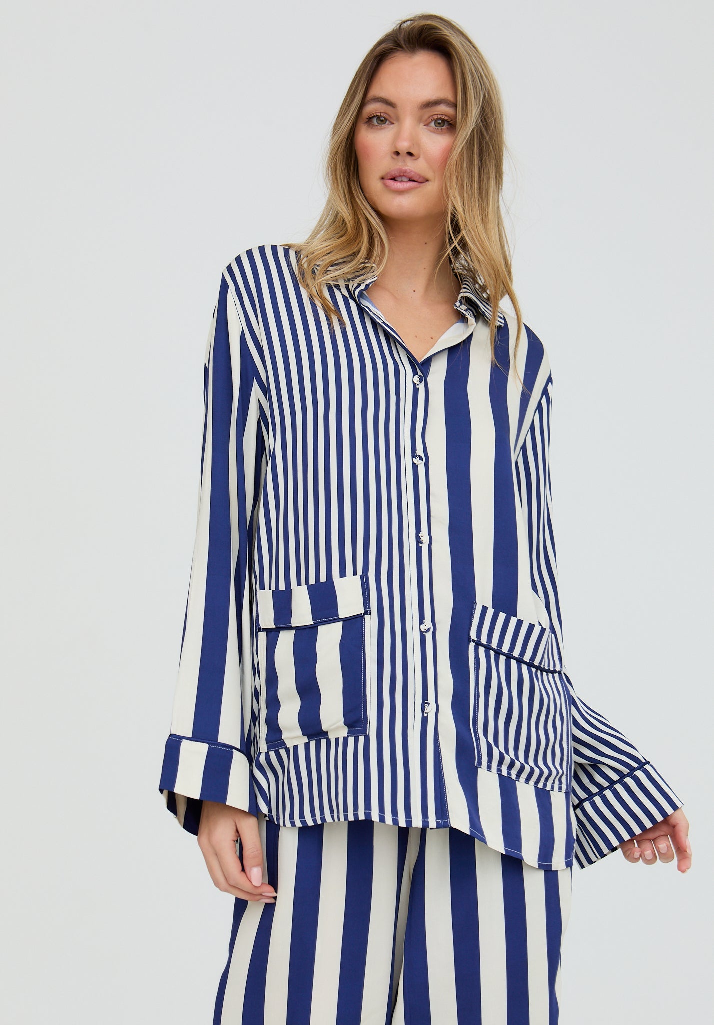 Woman wearing a blue and white striped outfit on a plain background