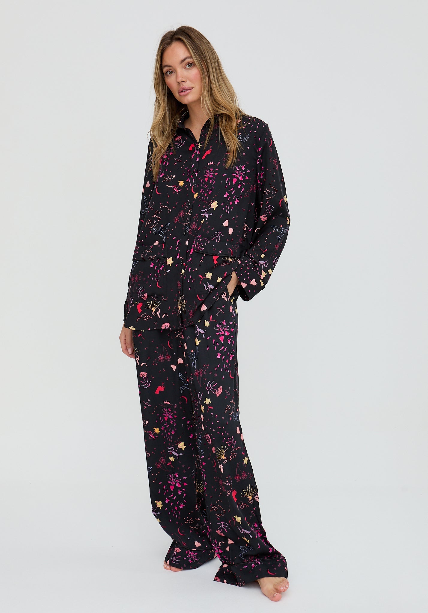 Woman wearing a black floral pajama set on a white background