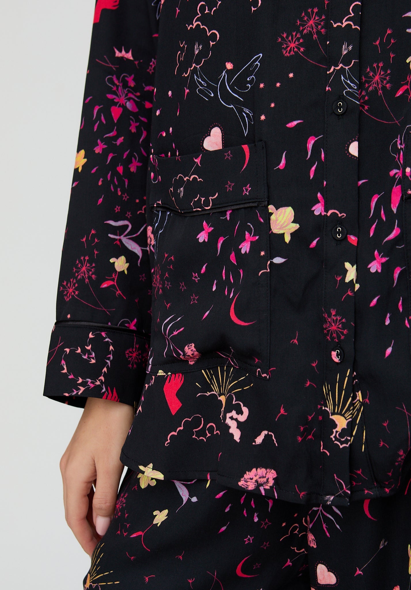 Black shirt with colorful floral and abstract patterns on a white background