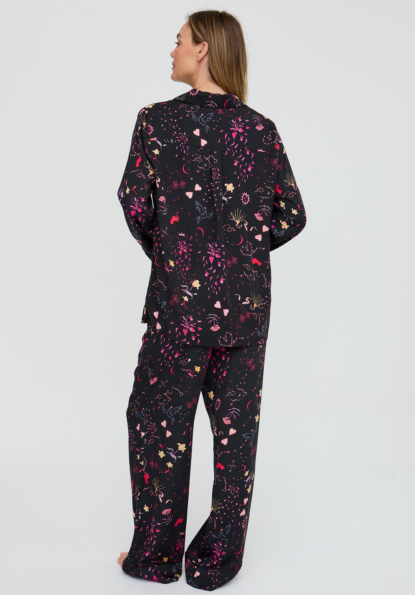 Person wearing a black floral patterned outfit on a light gray background