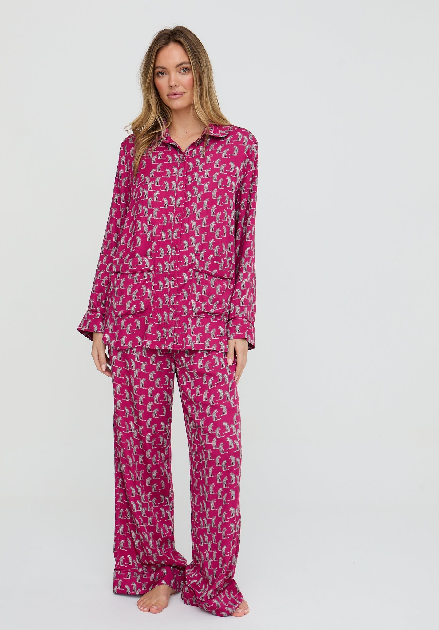 Woman wearing a pink patterned pajama set on a white background