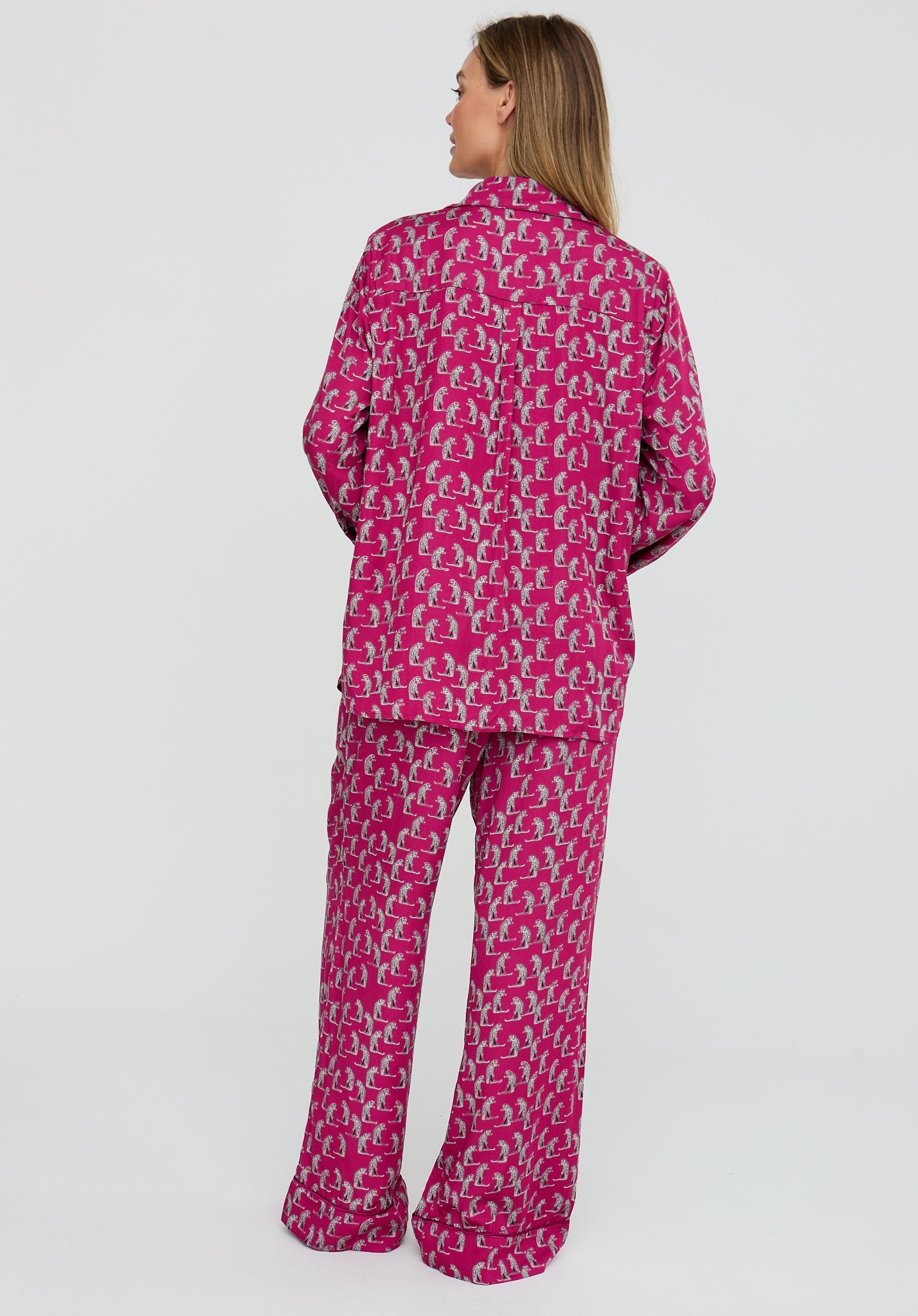 Person wearing a pink patterned pajama set on a white background