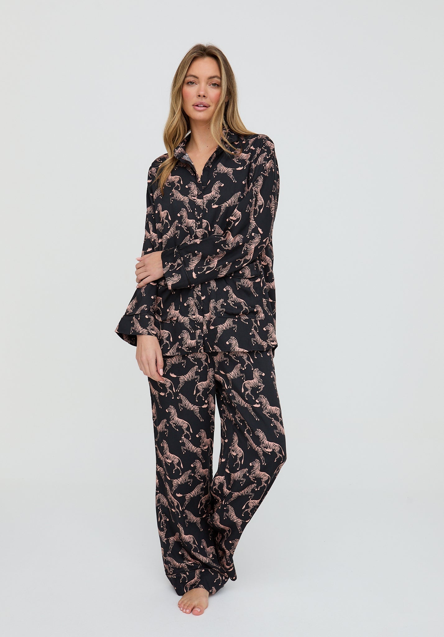 Woman wearing a black pajama set with a pattern on a white background