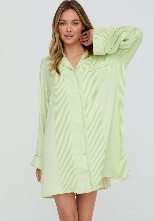 Woman wearing a light green button-up shirt dress on a white background