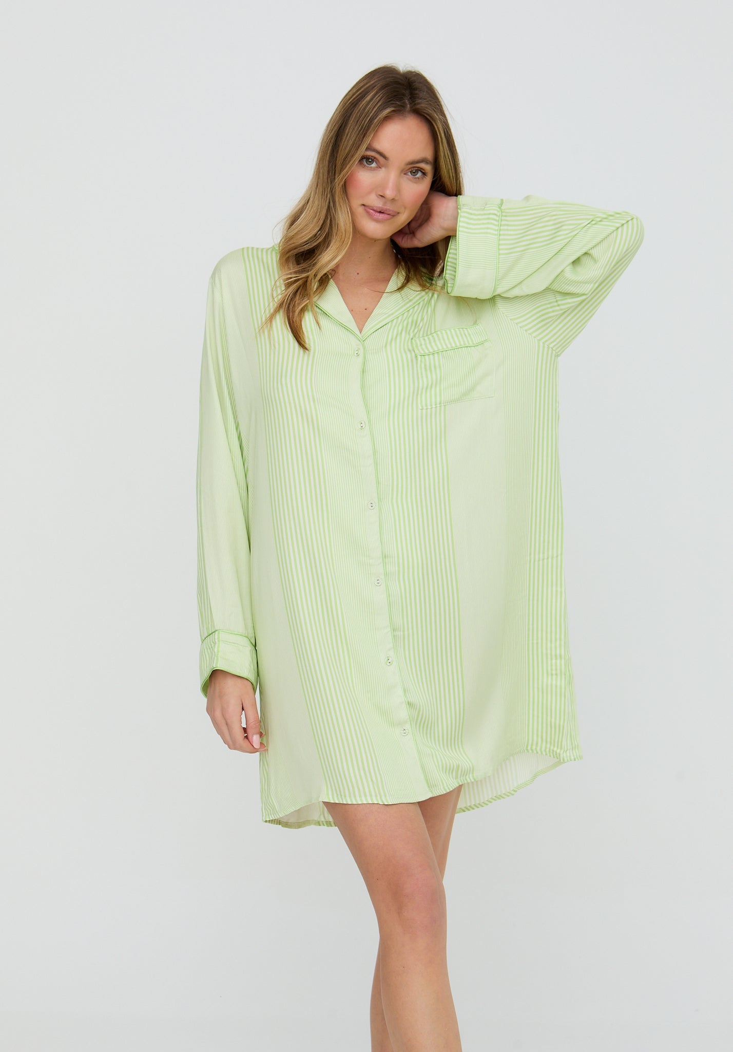 Woman wearing a light green dress against a white background