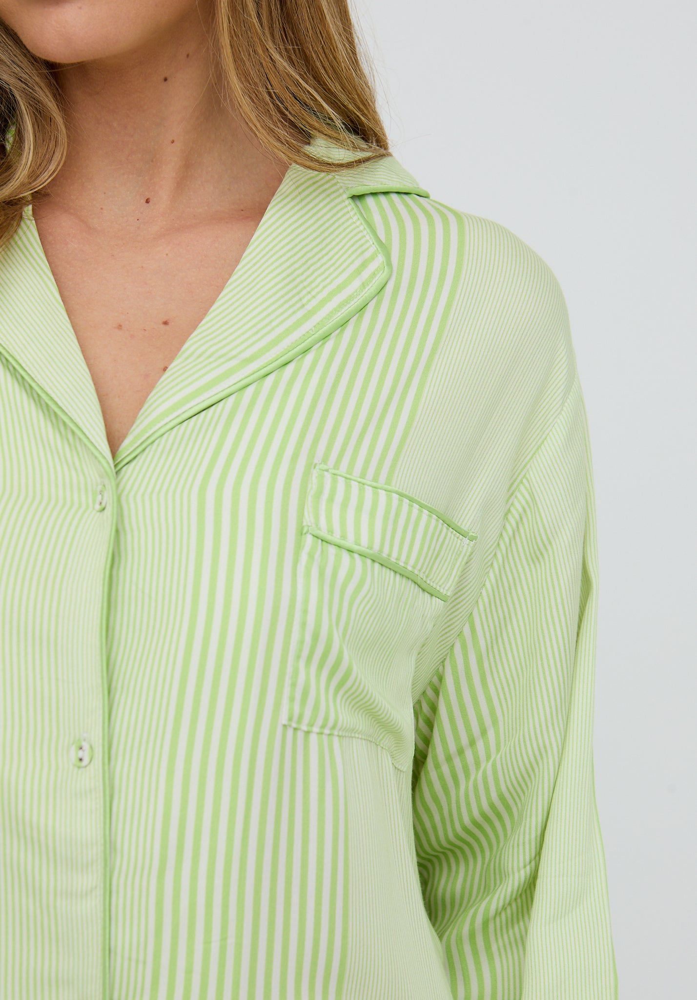 Light green striped shirt worn by a person on a white background