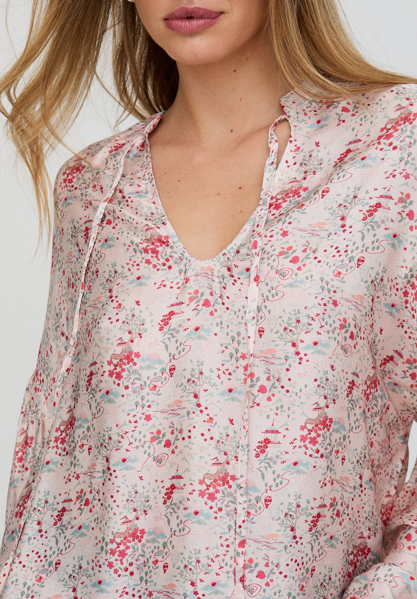 Floral patterned blouse worn by a person on a white background