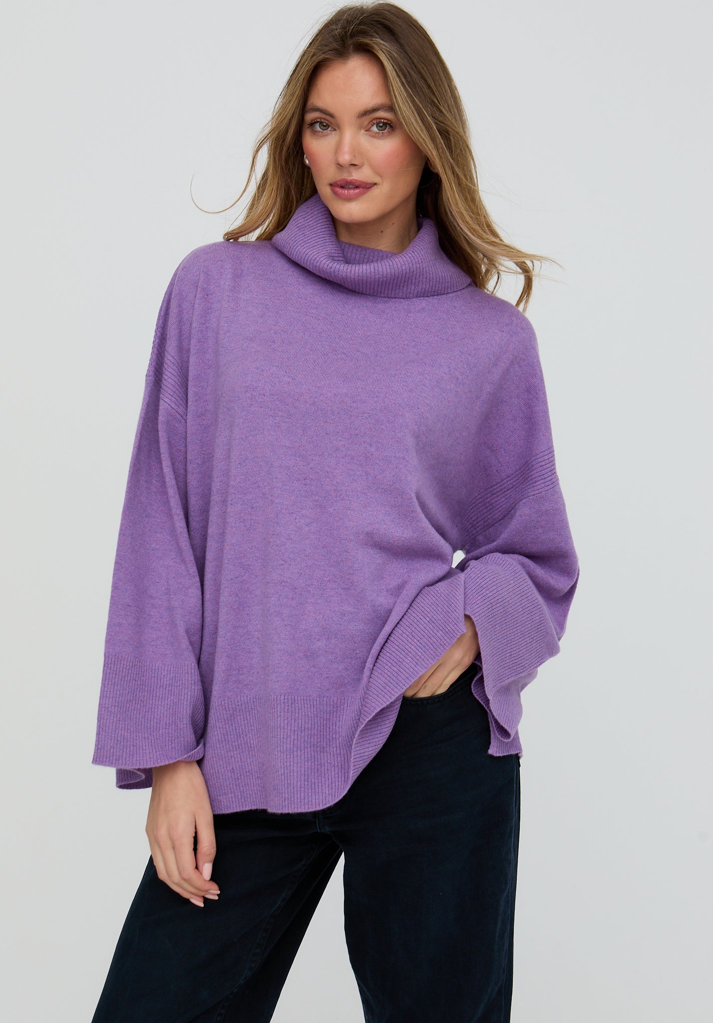 Woman wearing a purple sweater against a plain background