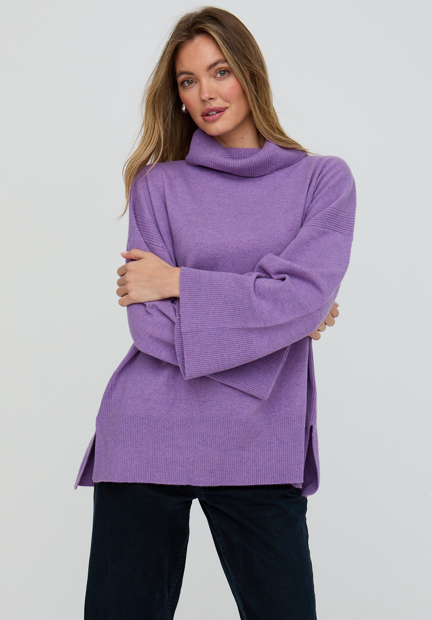 Woman wearing a purple sweater against a white background