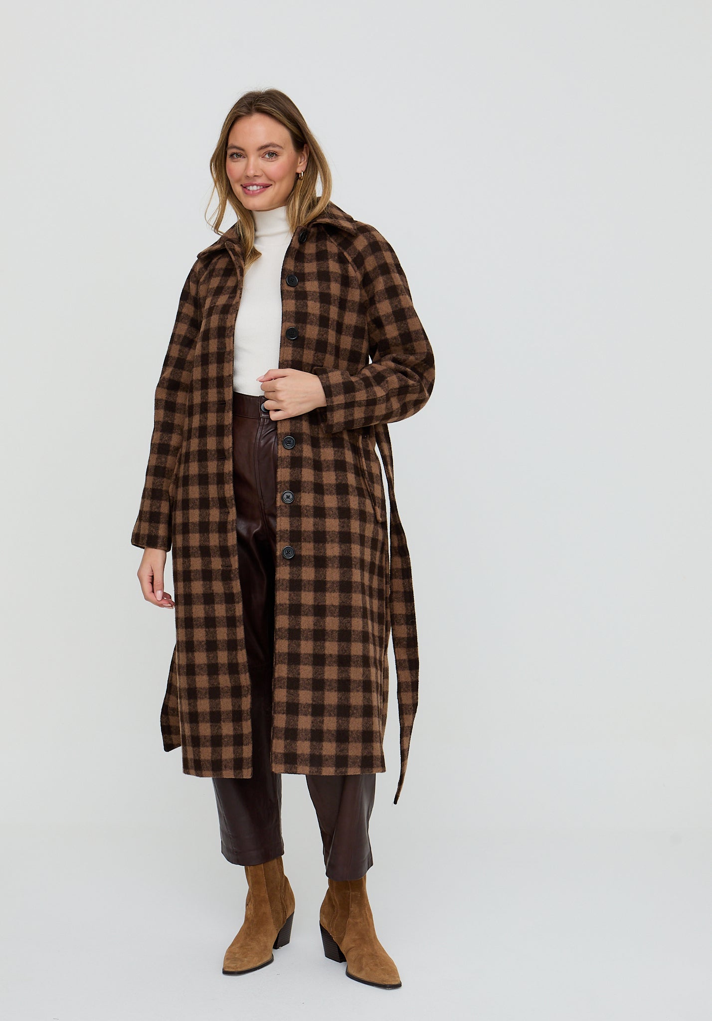Woman wearing a brown checkered coat on a white background