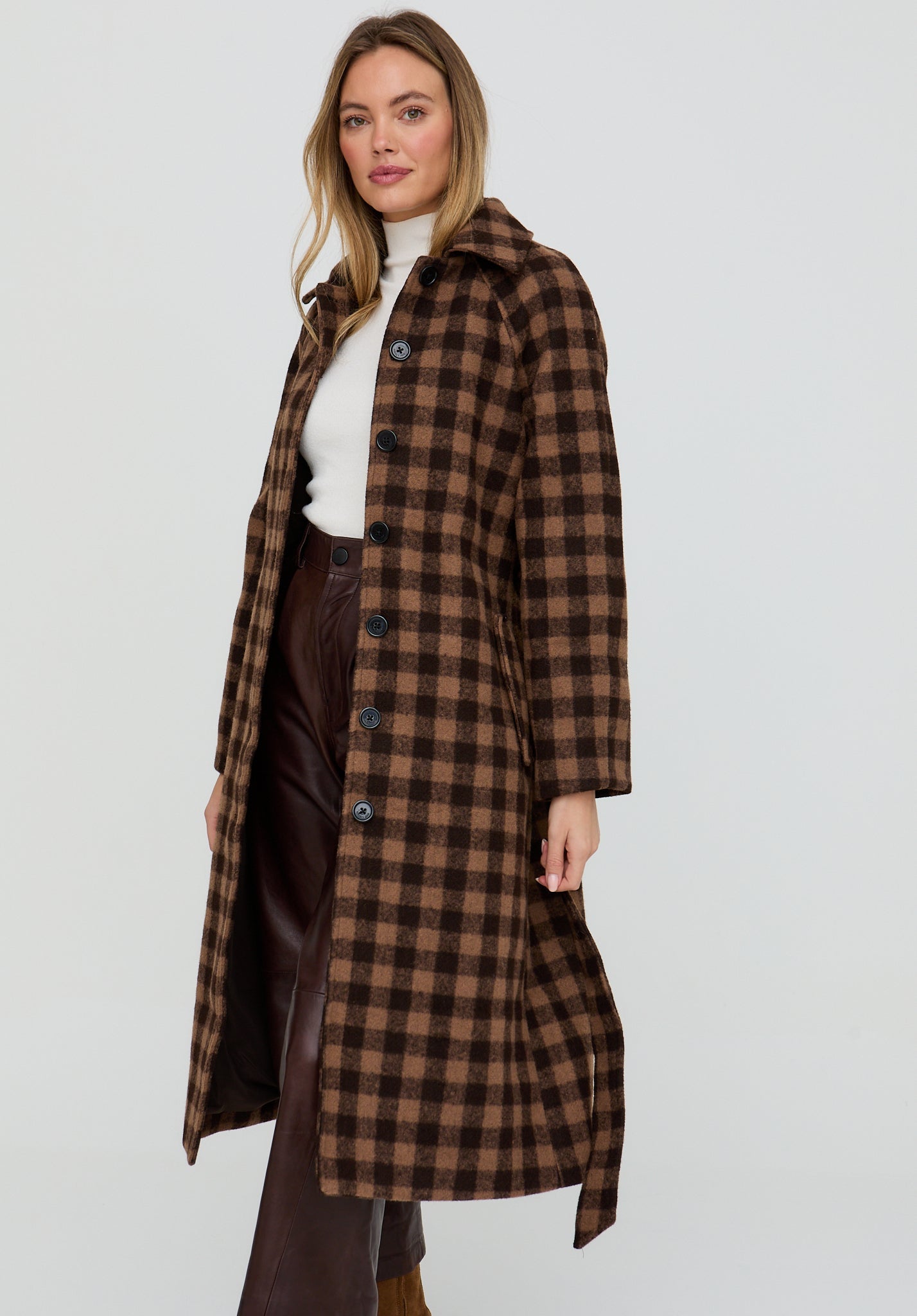 Woman wearing a brown checkered coat on a white background