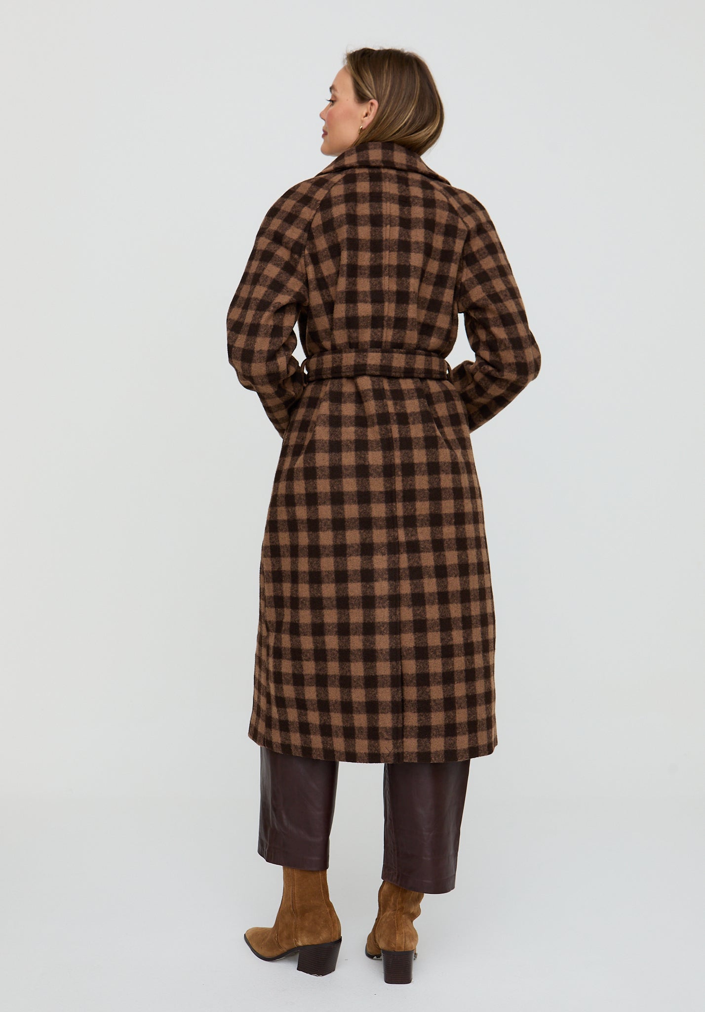 Woman wearing a brown checkered coat on a white background