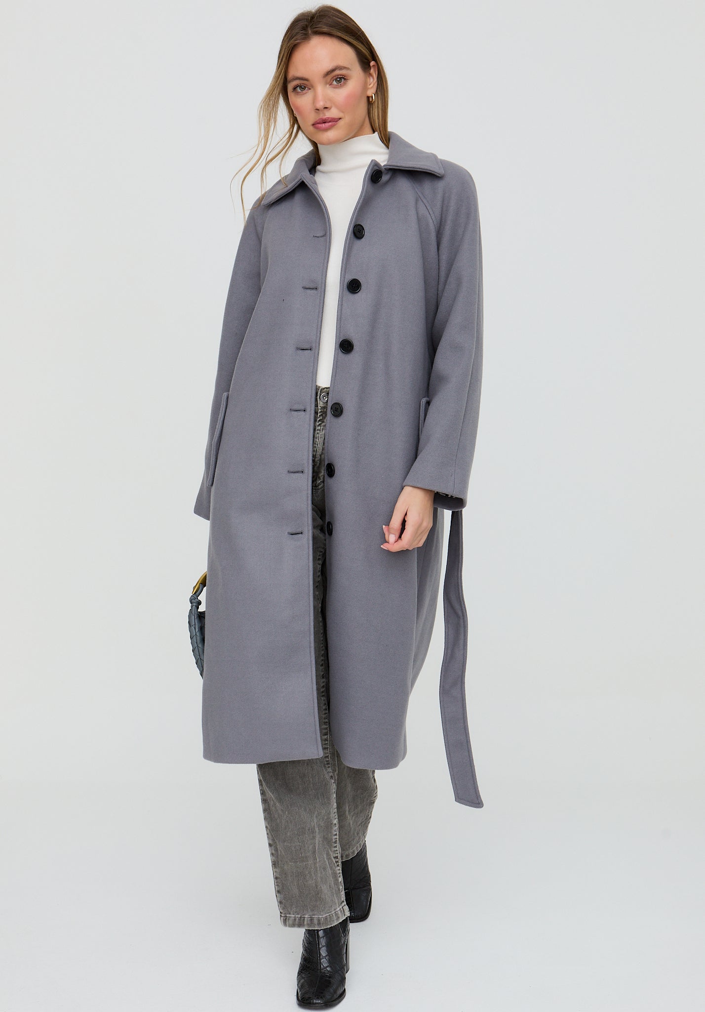 Woman wearing a gray coat on a white background