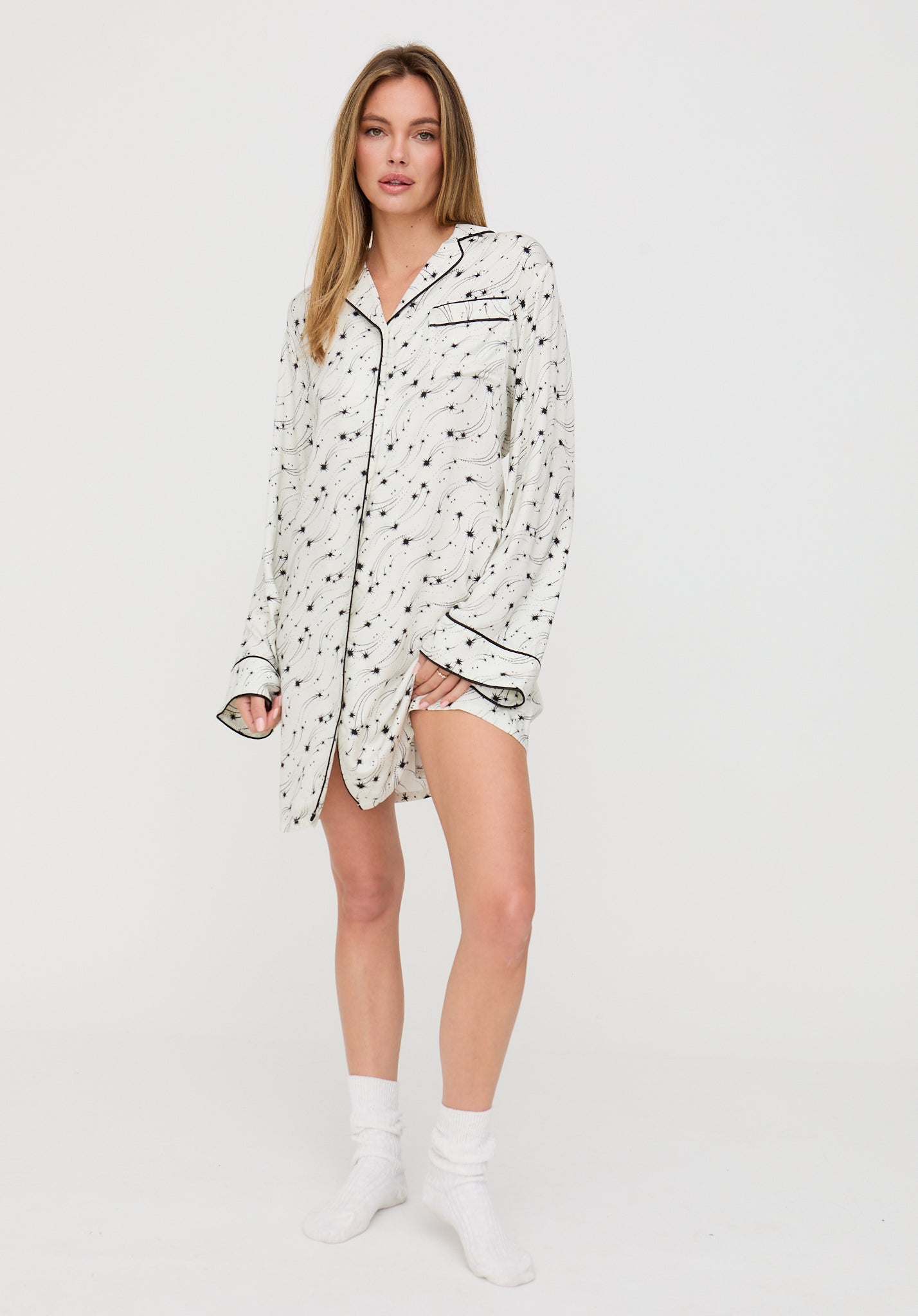 Woman wearing a patterned pajama shirt on a white background