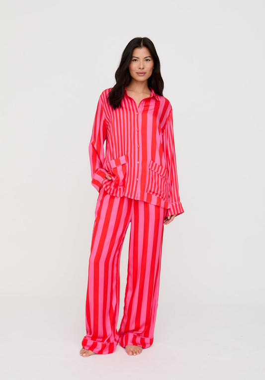 Woman wearing a red and white striped pajama set on a white background