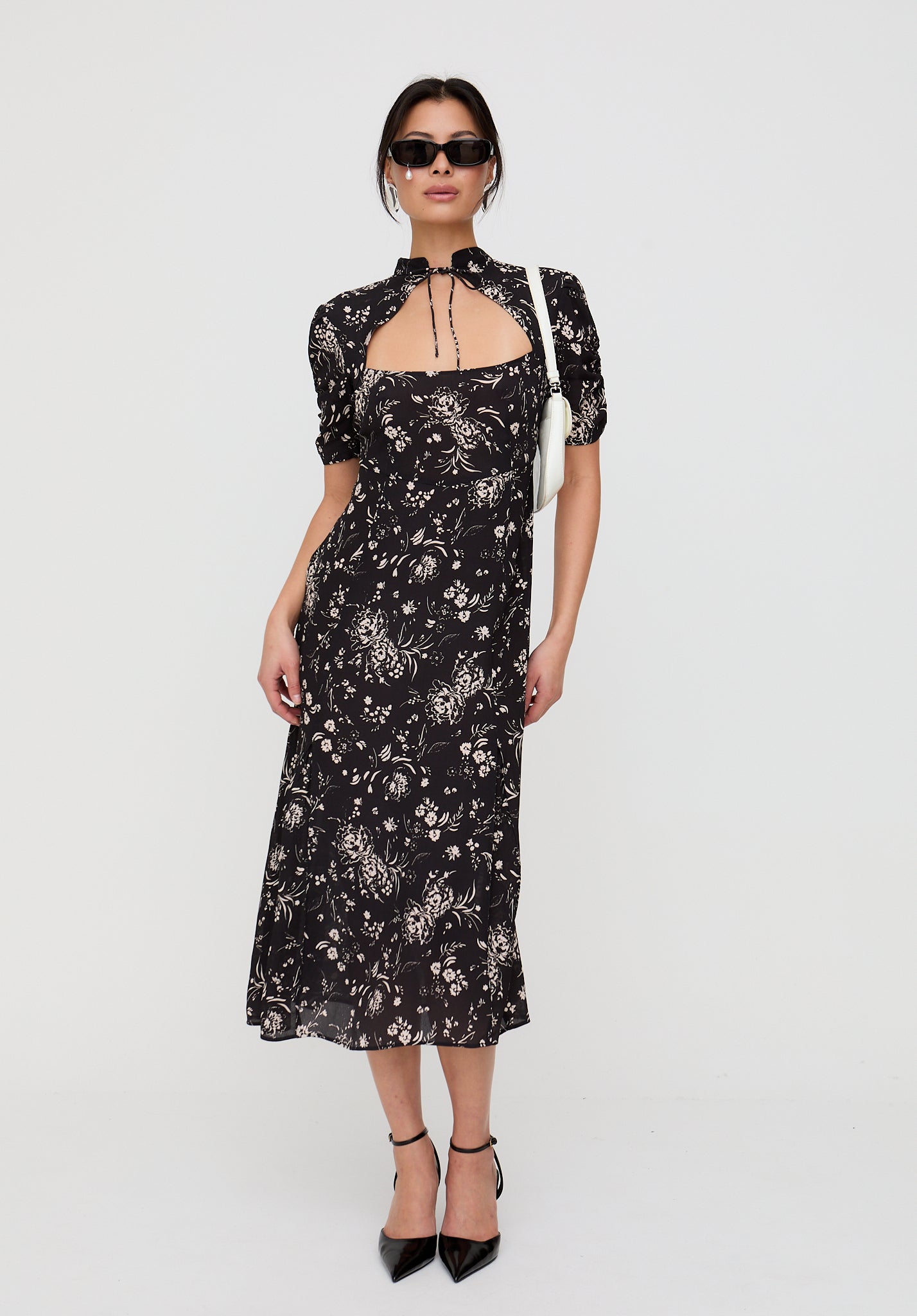 Woman wearing a black floral dress on a white background