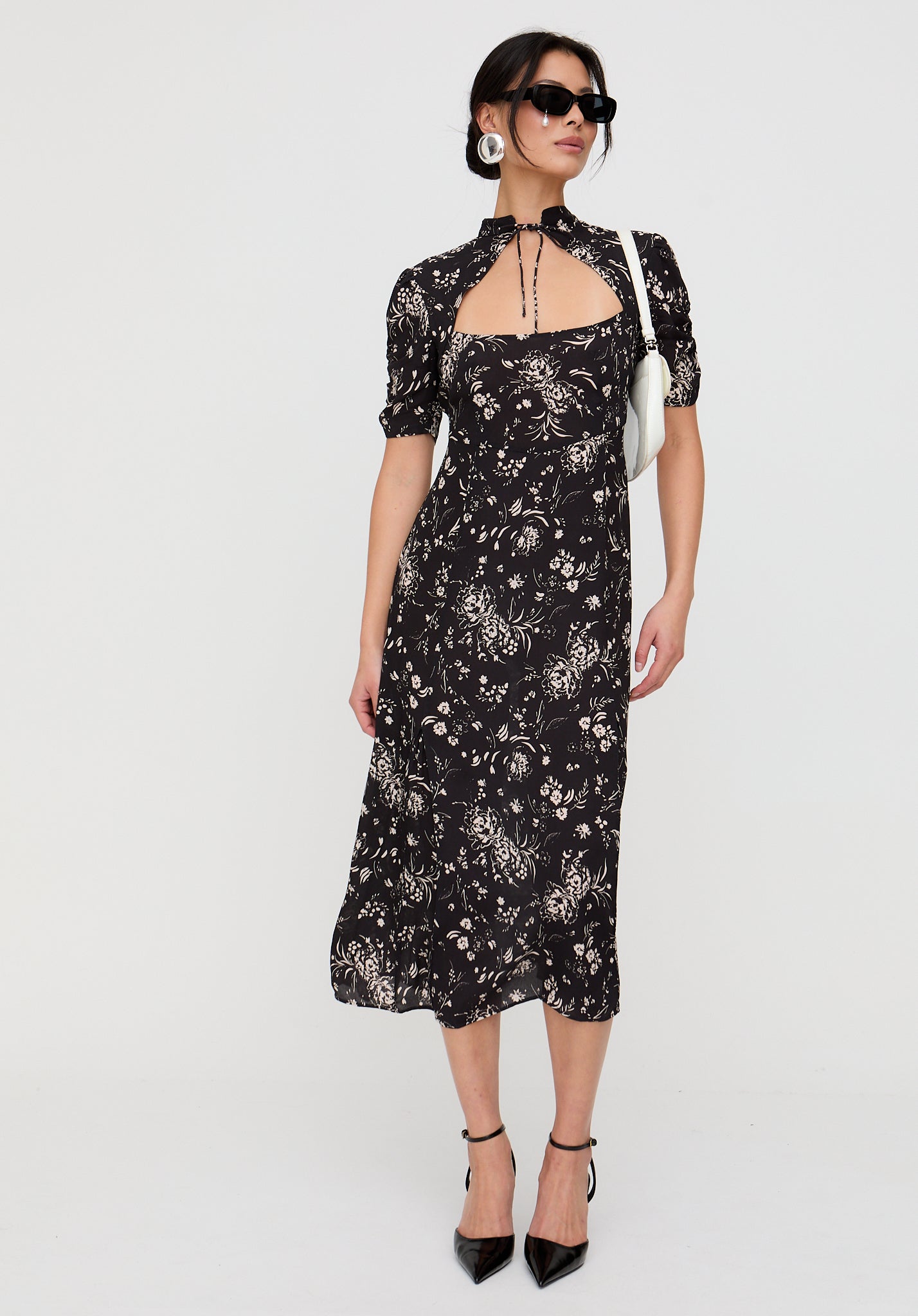 Woman wearing a black floral dress on a white background