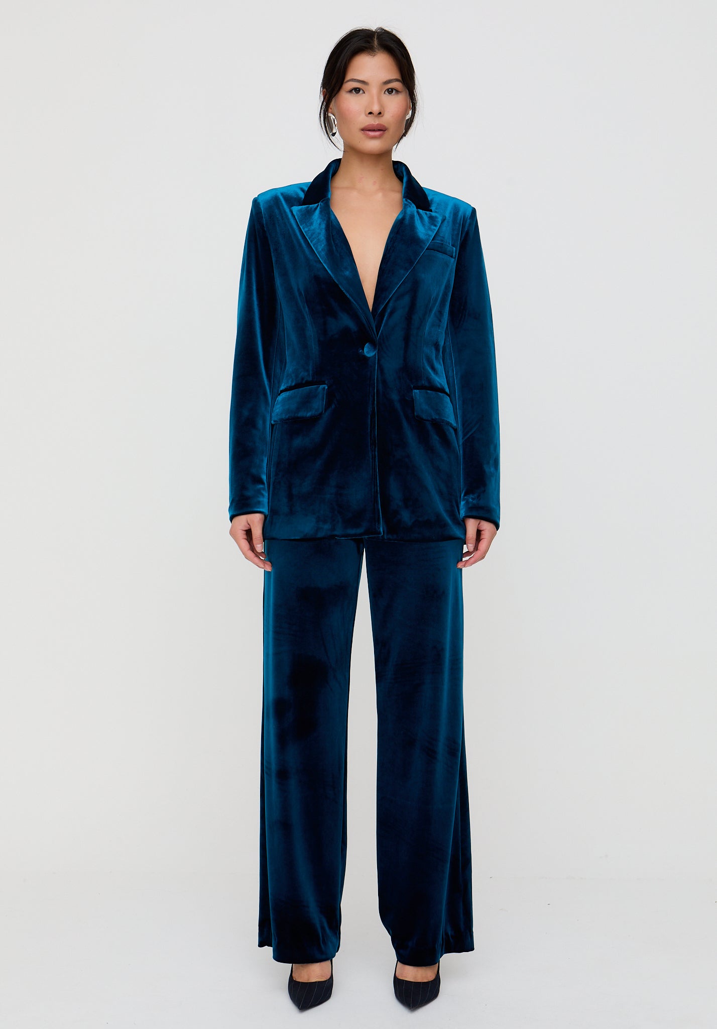 Woman wearing a blue velvet suit on a white background