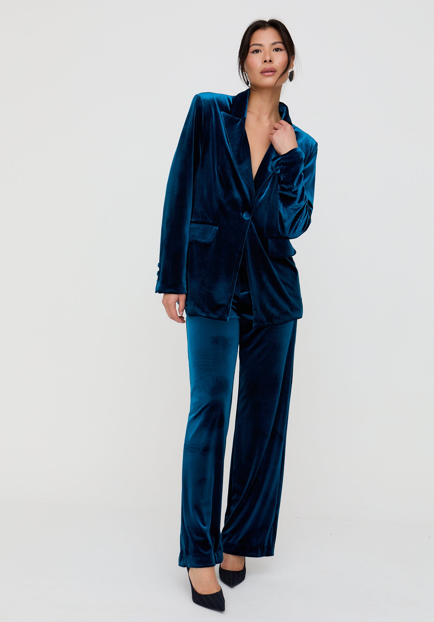 Woman wearing a blue velvet suit on a white background