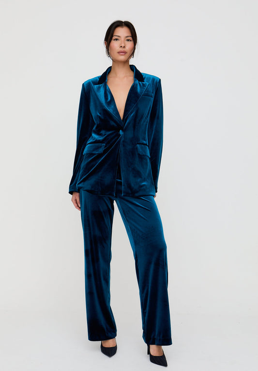 Woman wearing a teal satin suit on a white background