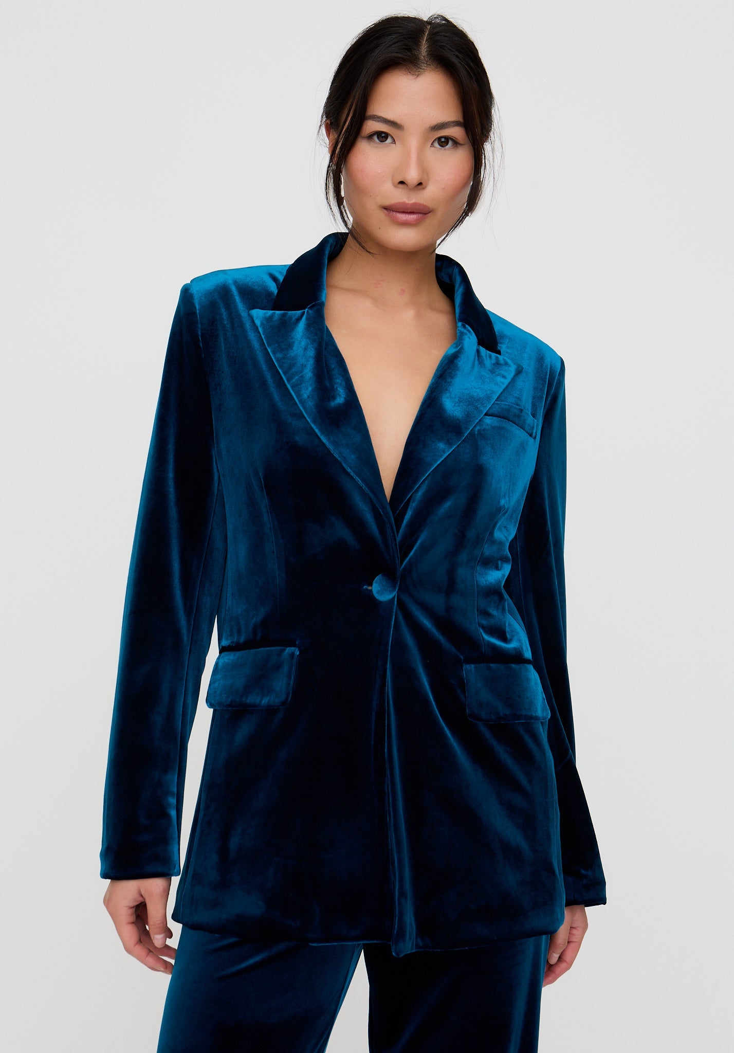 Woman wearing a blue velvet suit against a white background