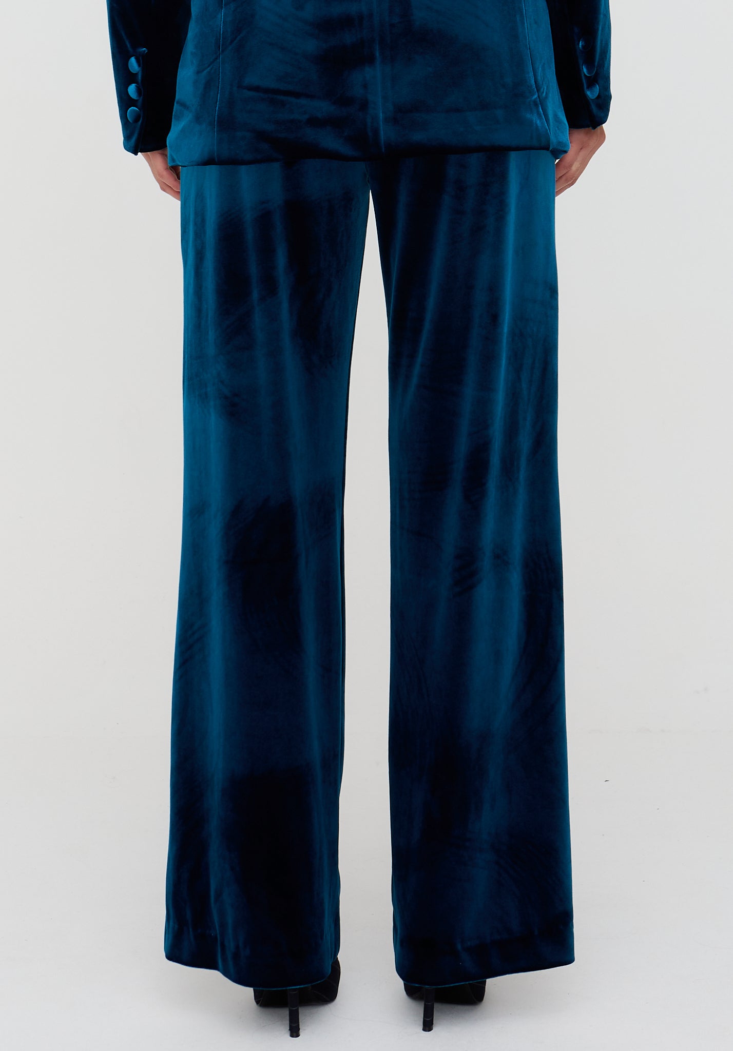 Person wearing a blue satin outfit with wide-leg pants on a white background