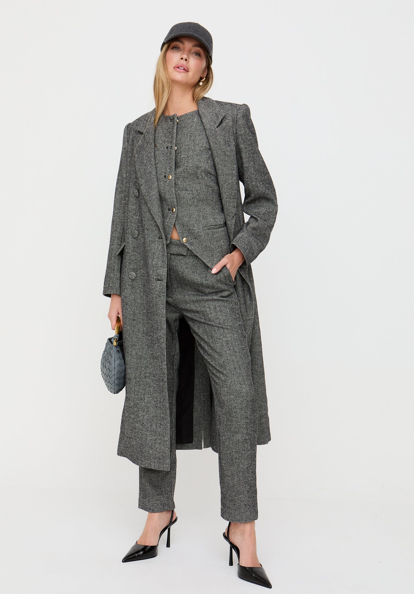 Woman wearing a gray coat and suit on a white background