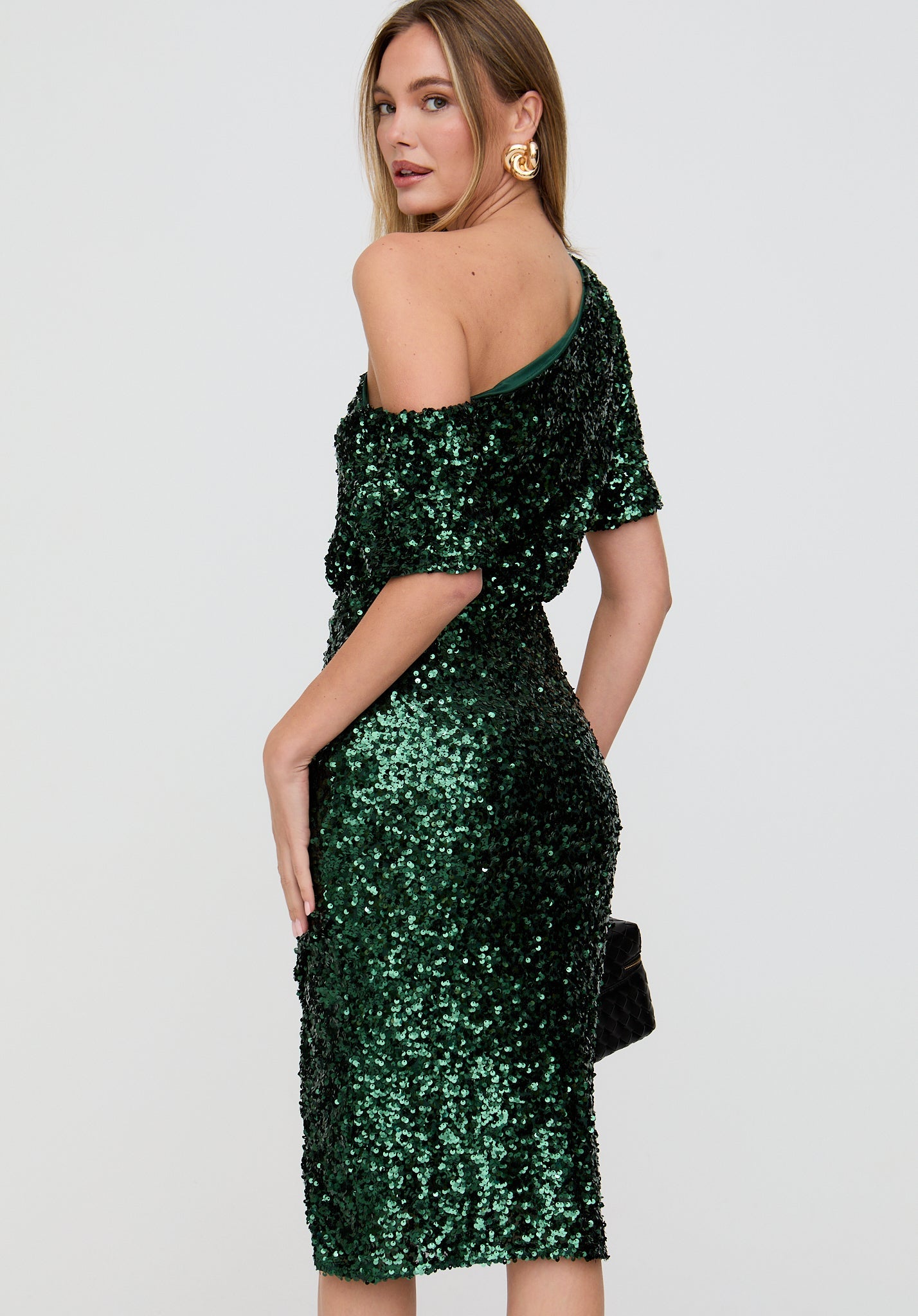 Woman wearing a green sequin dress on a white background